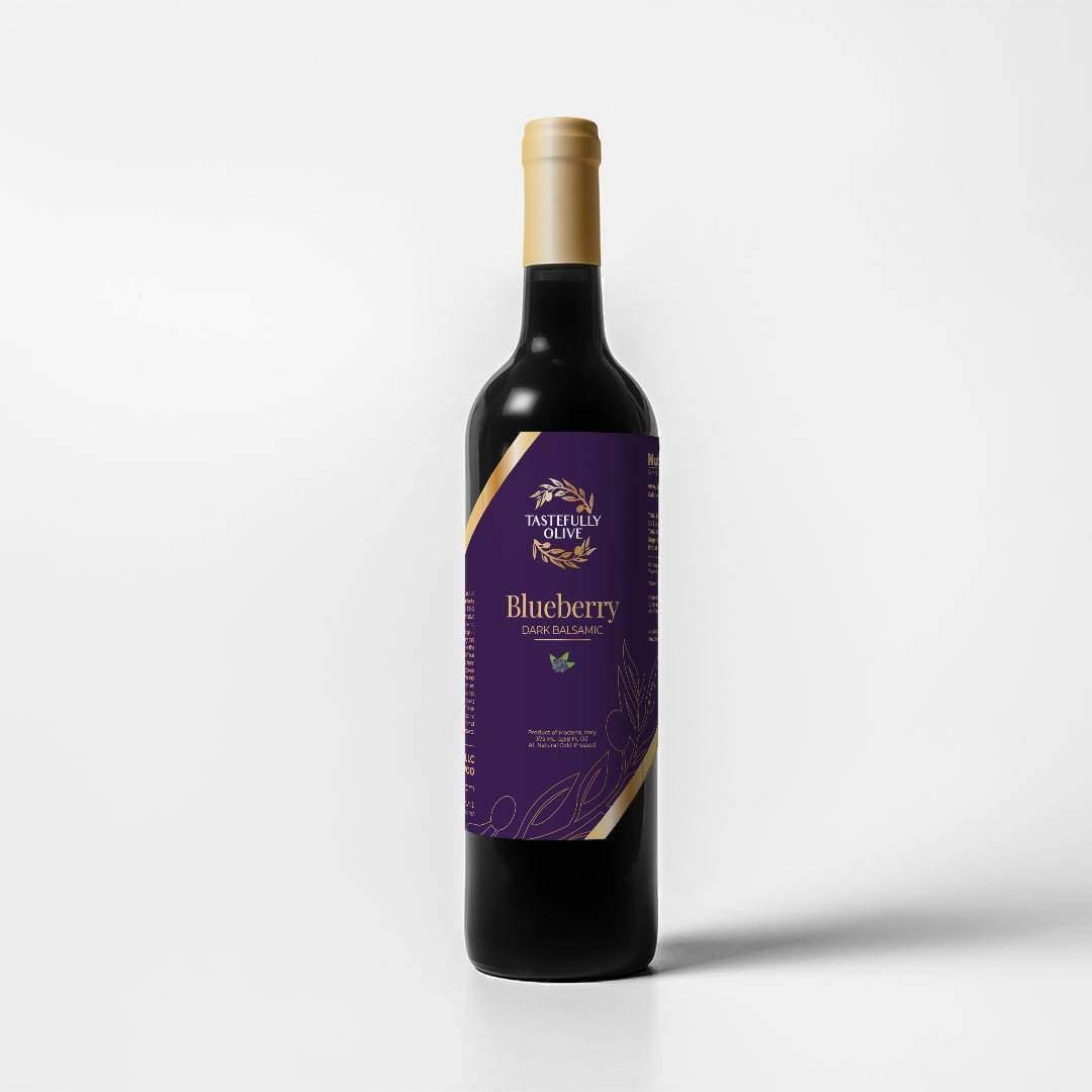 Tastefully Olive Blueberry dark balsamic bottle with a purple label and gold cap on a white background.
