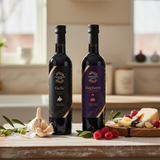Tastefully Olive Garlic olive oil and Raspberry dark balsamic bottles with garlic, raspberries, and cheese drizzled with balsamic.