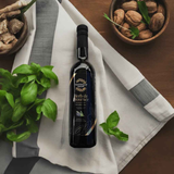 Overhead view of Tastefully Olive Herb de Provence infused oil on a striped cloth with basil, walnuts, and ginger.