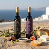 Tastefully Olive Koroneiki olive oil and Fig dark balsamic bottles with figs, bread, cheese, and a dipping bowl overlooking the sea.