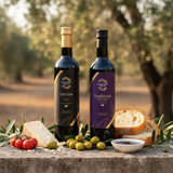 Tastefully Olive Leccino olive oil and Traditional dark balsamic bottles with black and gold caps, bread, cheese, tomatoes, olives, and a balsamic bowl.