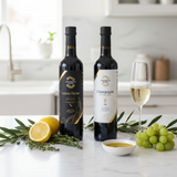 Tastefully Olive Lemon Thyme olive oil and Champagne white balsamic bottles with lemon, thyme, grapes, and a champagne flute.