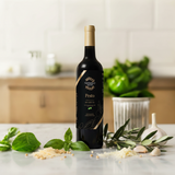 Tastefully Olive Pesto infused olive oil bottle with basil, garlic, and olive branches on a kitchen counter.