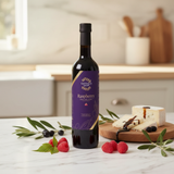 Tastefully Olive Raspberry dark balsamic bottle with raspberries, mint, olive branches, and cheese drizzled with balsamic.