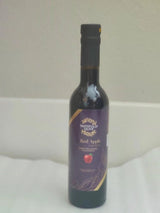 Tastefully Olive Red Apple dark balsamic bottle with a purple label and black cap against a pale background.