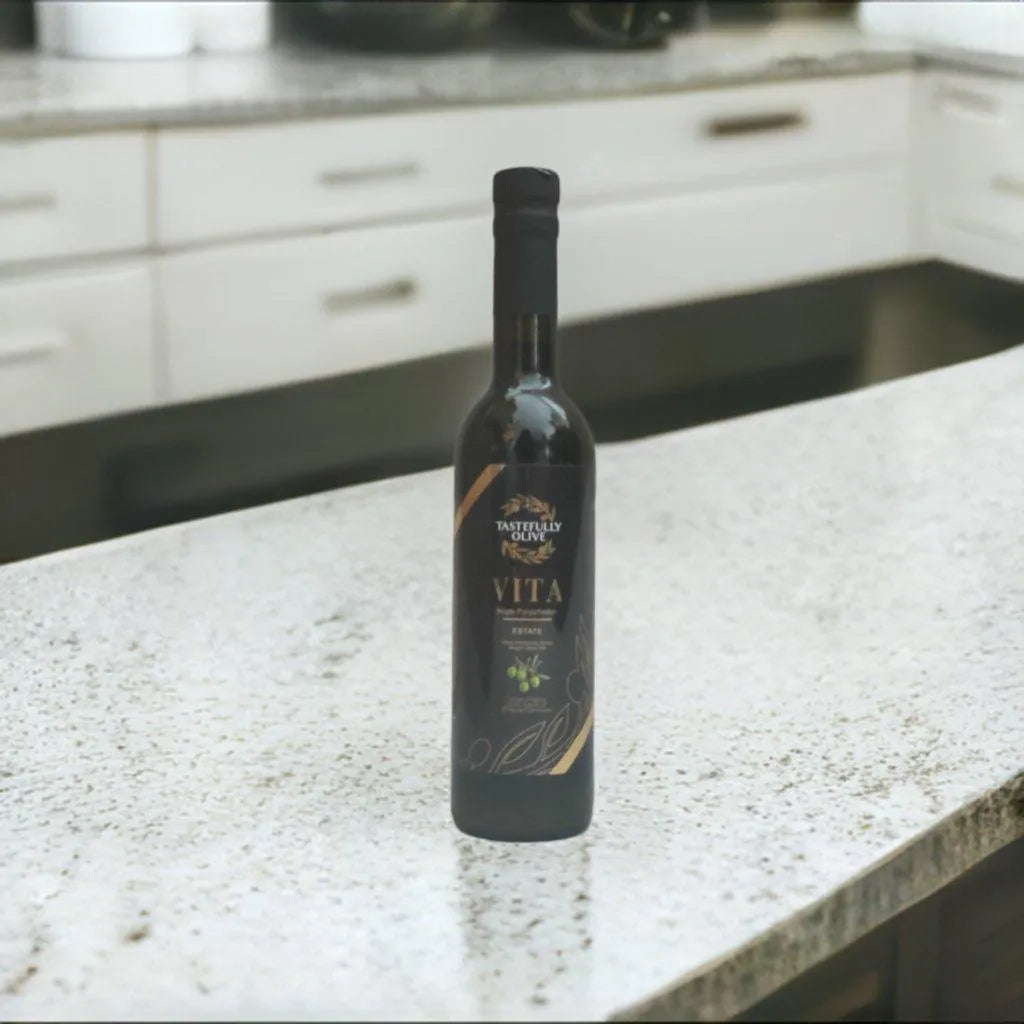 Tastefully Olive Vita olive oil bottle standing on a light kitchen countertop.