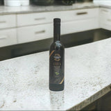 Tastefully Olive Vita olive oil bottle standing on a light kitchen countertop.